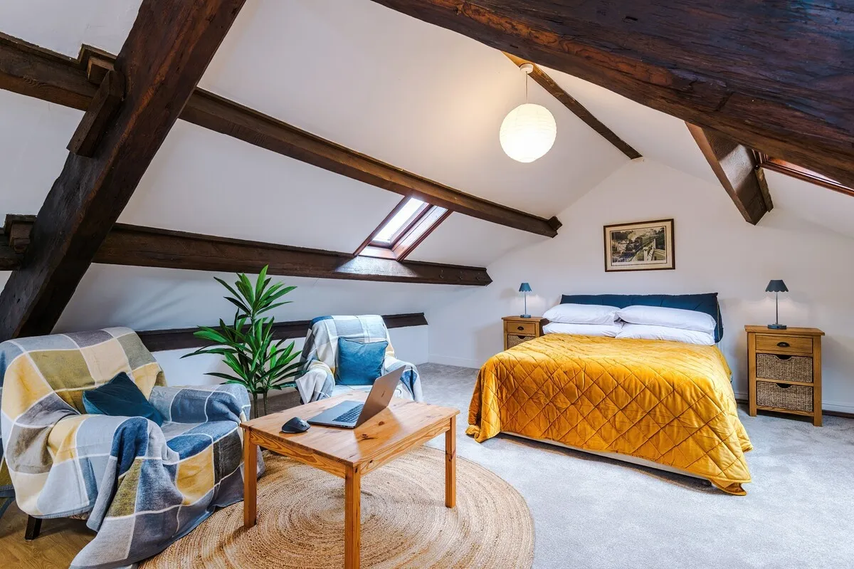 Attic bedroom with an armchair, coffee table and double bed