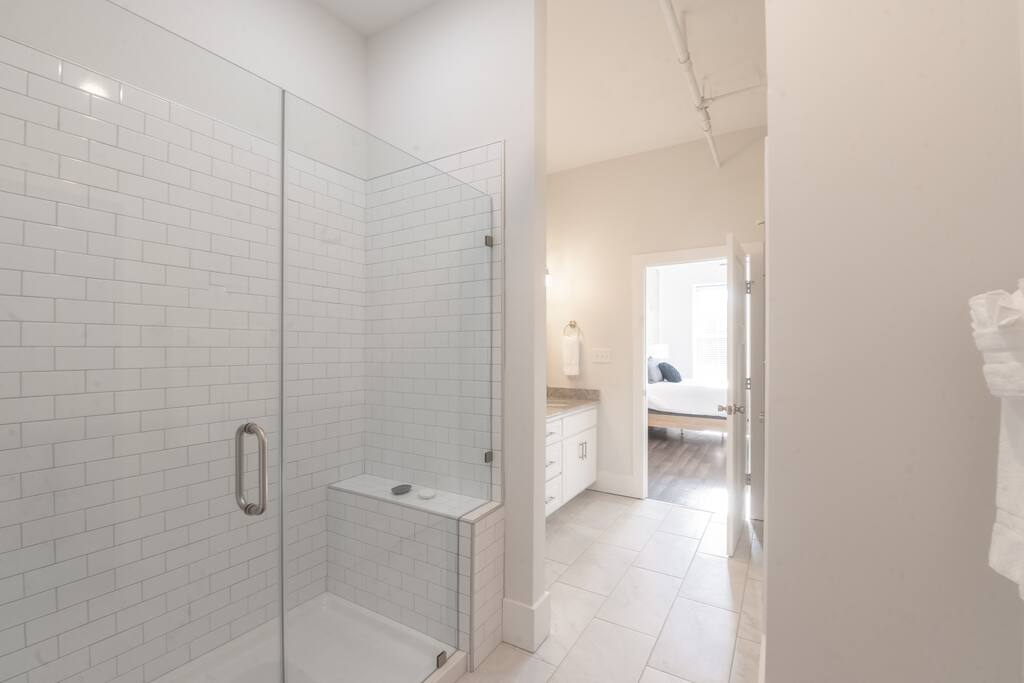 A modern bathroom with a glass-enclosed shower and white subway tile
