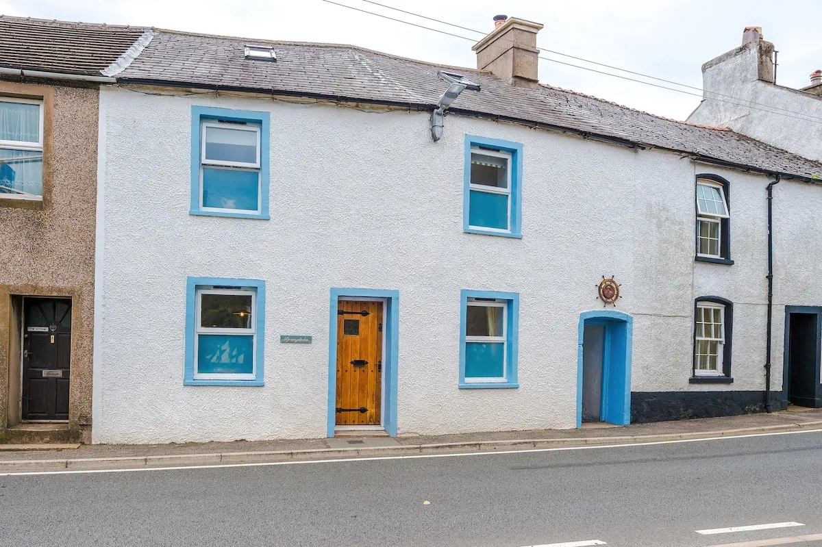 Springholm Cottage from the street, a white terrace with blue window frames