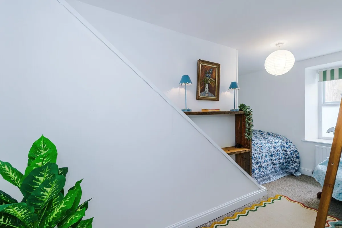 Bedroom under the eaves with a blue floral quilt