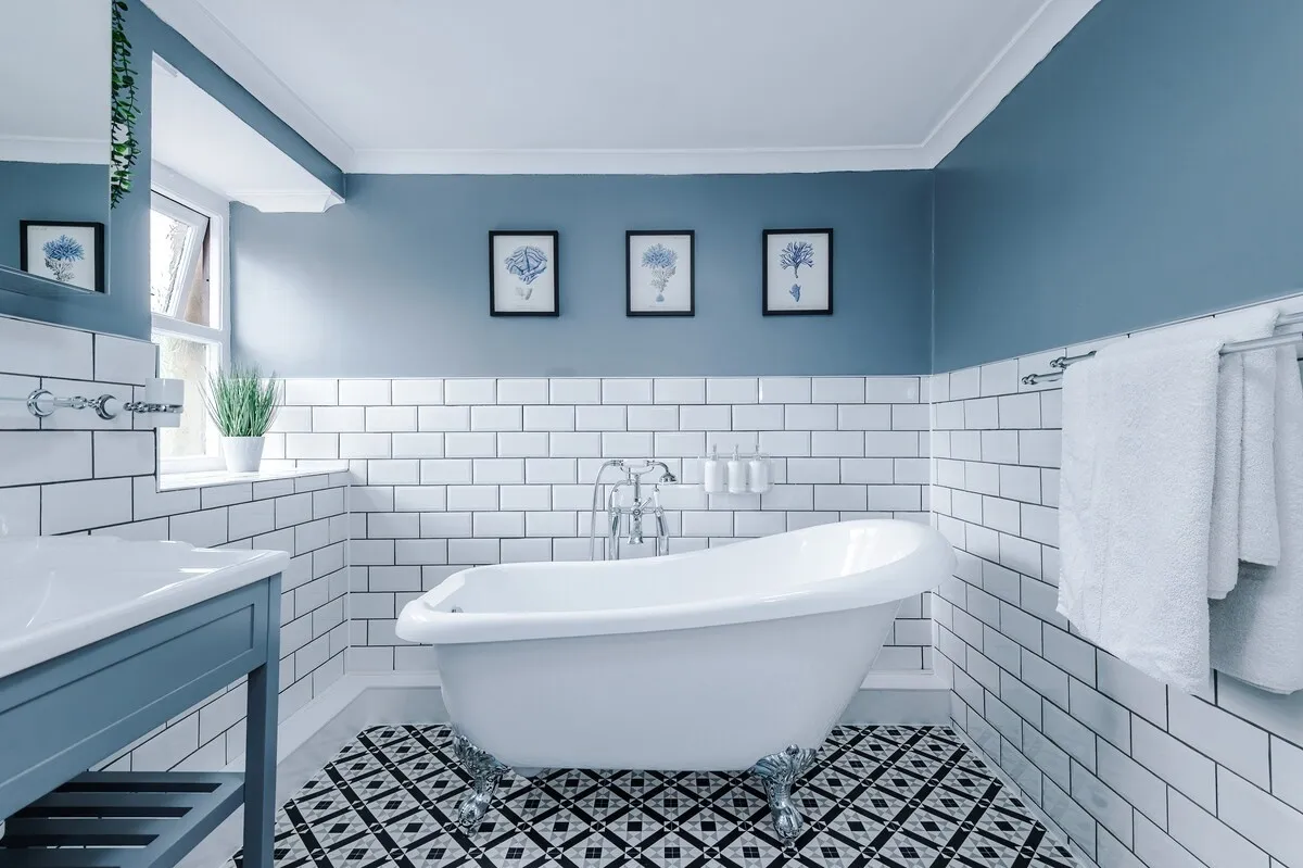 Freestanding roll-top bath under botanical prints