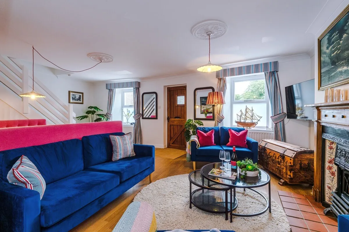 Open-plan lounge with navy sofas and a period fireplace