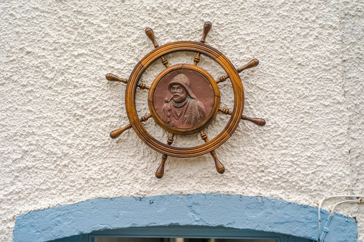Ship’s wheel plaque above the arch