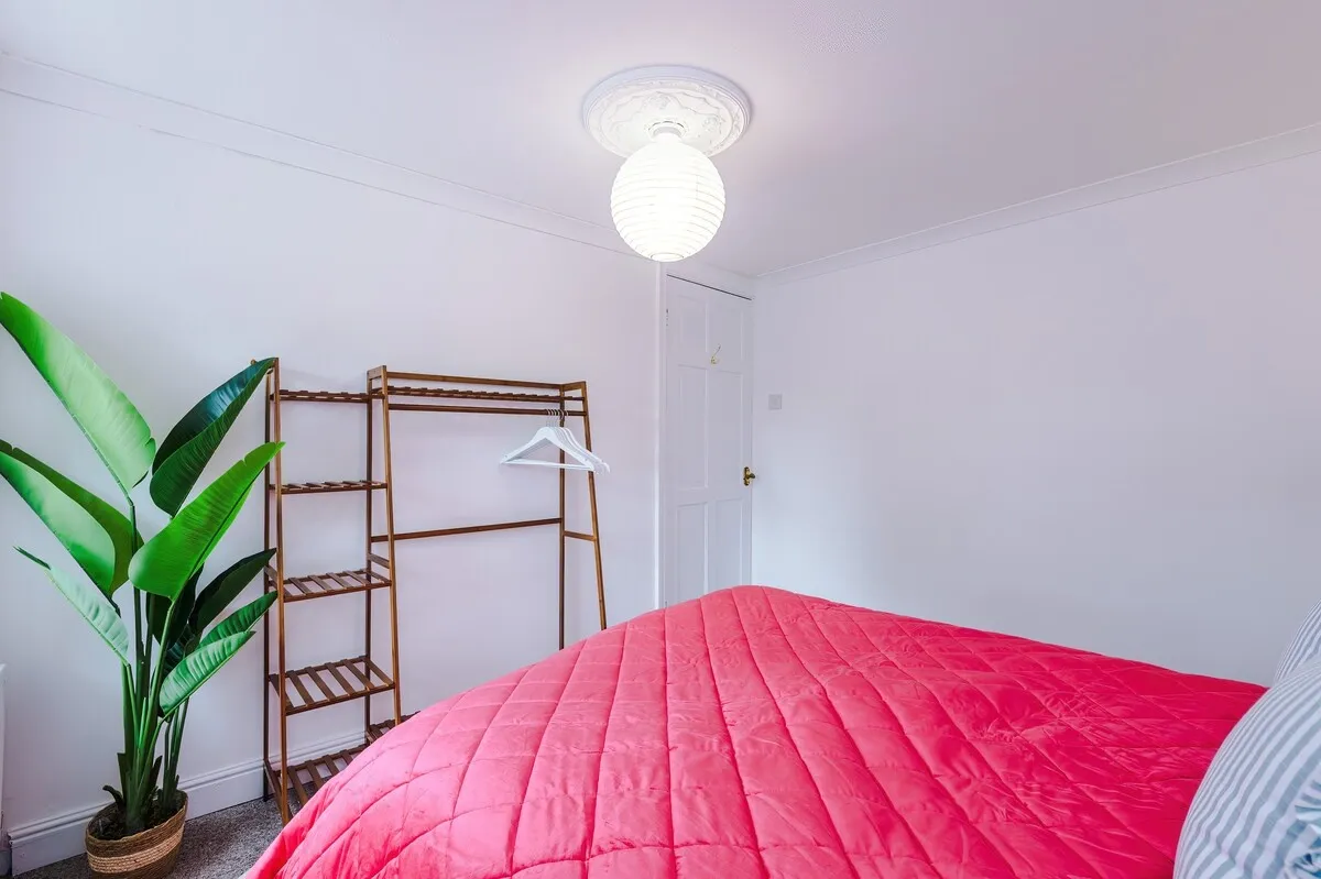 Double bedroom with a clothes rail and a tall plant