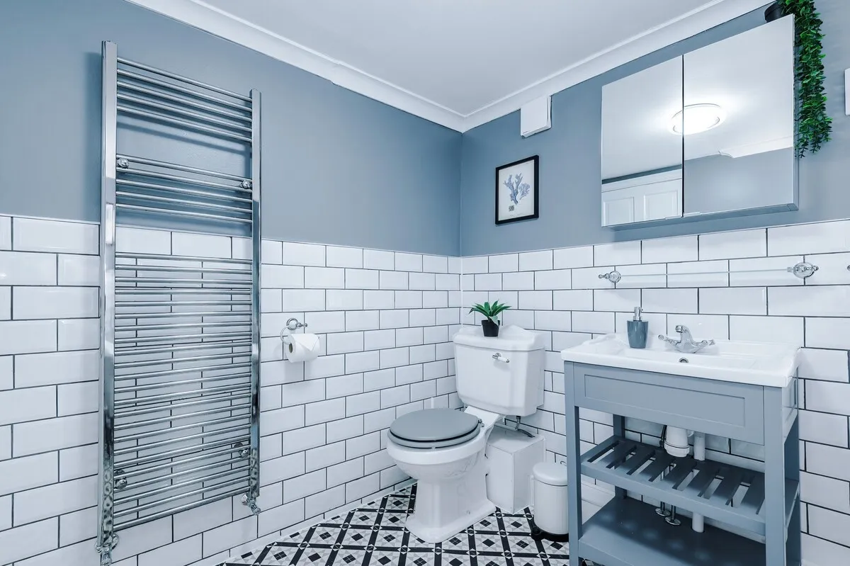 Bathroom with a heated towel rail, vanity and patterned floor