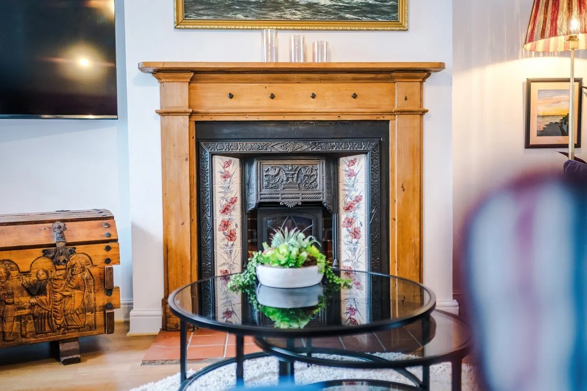 Cast-iron fireplace with a pine surround and carved chest