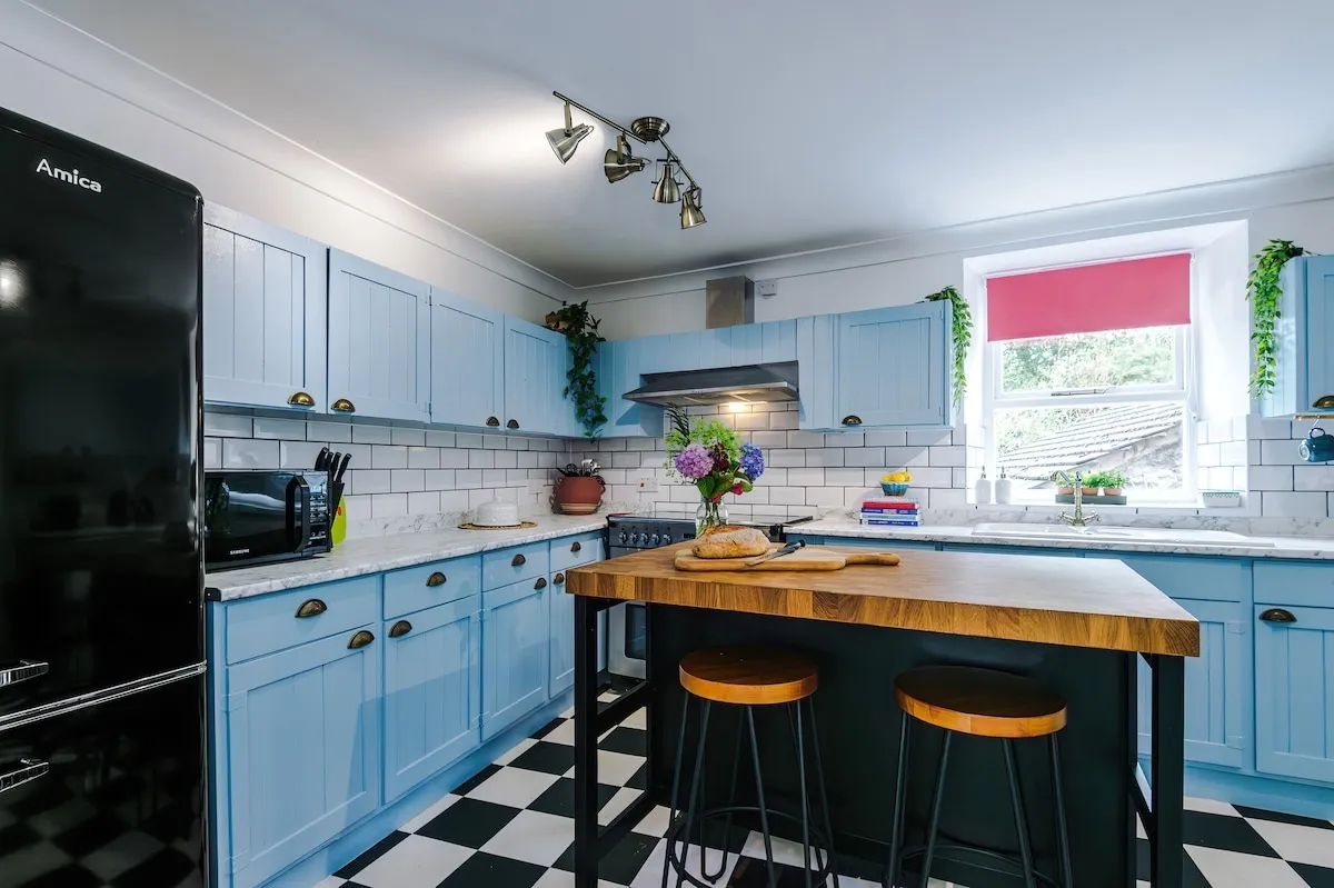 Kitchen from the doorway, with the tall fridge-freezer and island