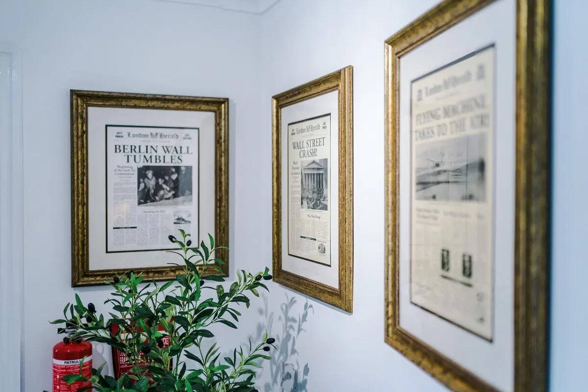 Framed newspaper front pages on the landing